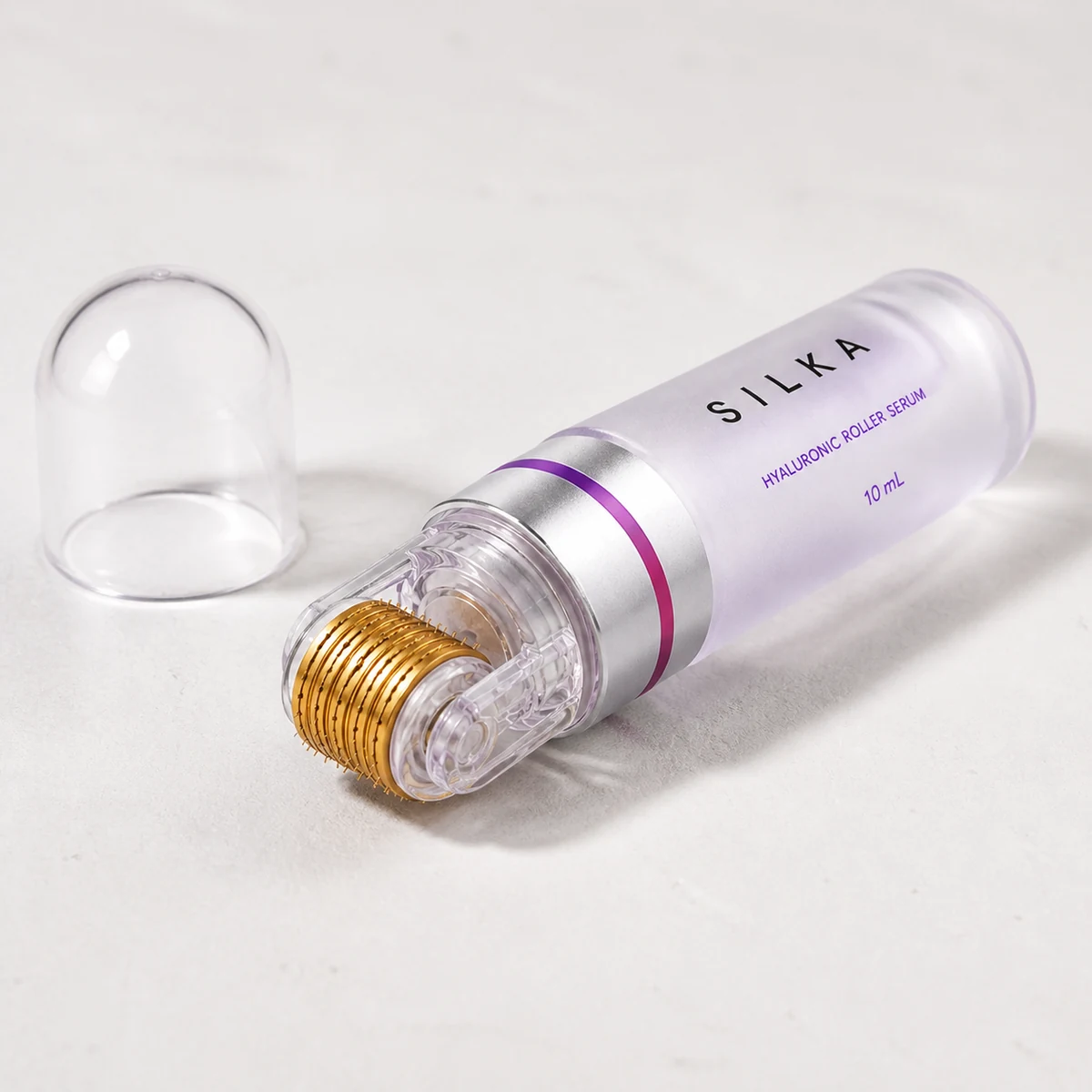 The Silka roller bottle lying uncapped with the clear cover beside it, the bare gold roller head facing the camera
